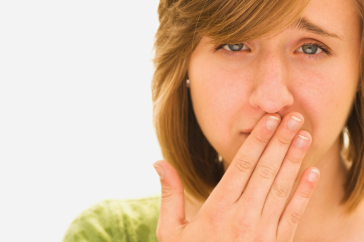 woman wearing a green shirt is seen covering her mouth